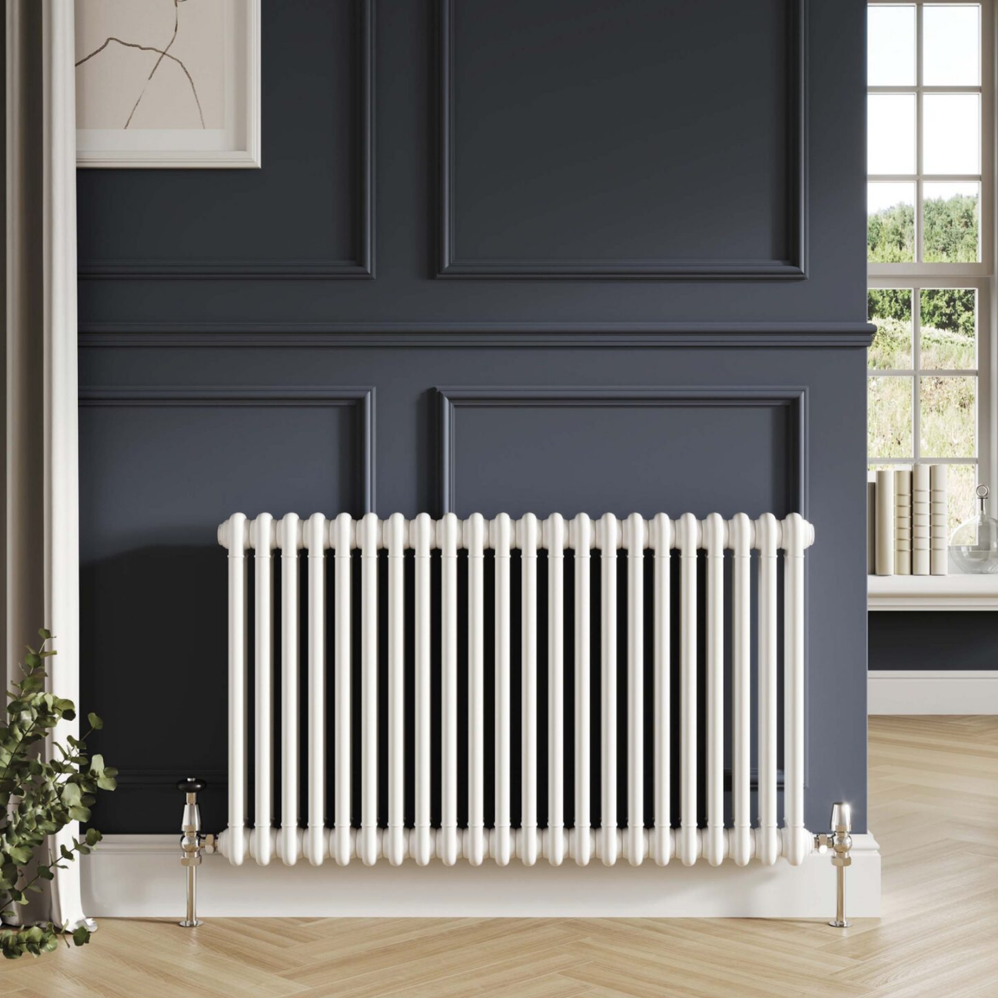 A white cast iron radiator with decorative finials, mounted on a white base against a dark navy blue paneled wall in a styled room setting.