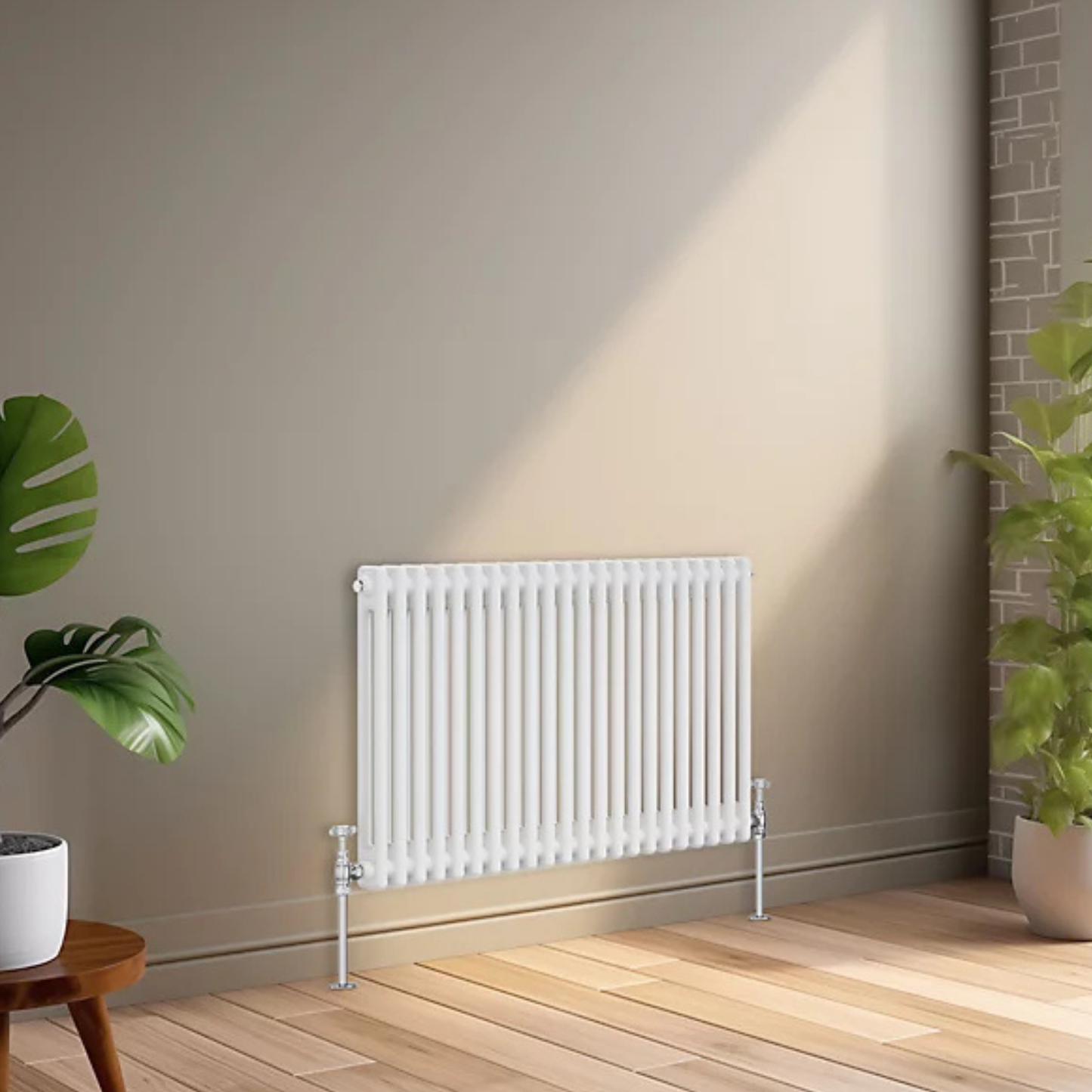 A white panel radiator mounted on a beige wall in a modern room with light wood flooring, a potted green plant on the left, and a brick column on the right.